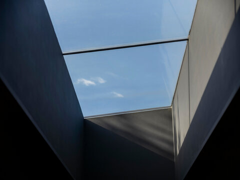 Angular modern skylight with blue sky view framed by clean geometric architectural lines - Powered by Adobe