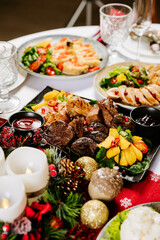 Grilled beef and chicken with roasted potatoes and sauce on festive holiday table