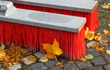 red street brooms with autumn leaves
