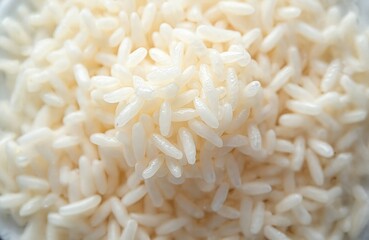 Fototapeta premium Closeup of cooked white rice. Heap of grains with detailed surface. Food industry backgrounds for culinary site. Source of energy, carbs. Ingredient for sushi, healthy balanced diet. Asian cuisine