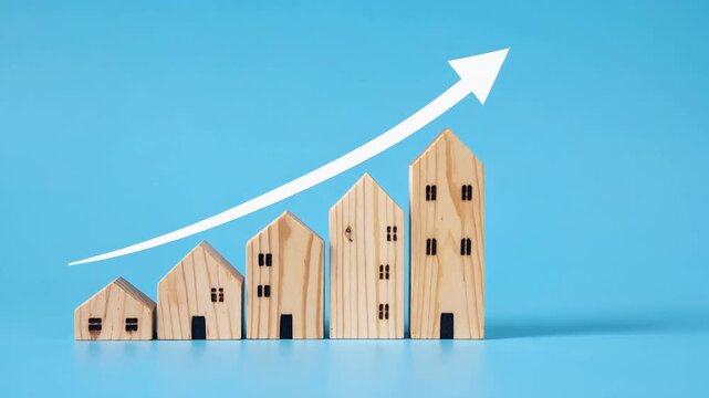 不動産の投資効果を示す木製住宅模型と上昇するビジネスグラフの構図