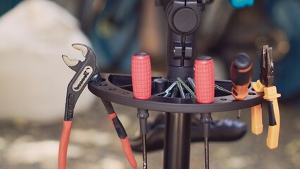 Detailed view of black woman organizing work tools for yearly outdoor bike maintenance. Close-up shot of african american person hands arranging various professional equipment for bicycle repair.