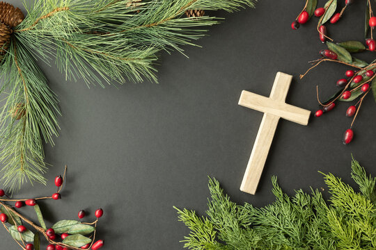 Cross with evergreen and berry frame on a black background