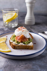 Healthy breakfast with poached egg on toast, avocado and salmon.