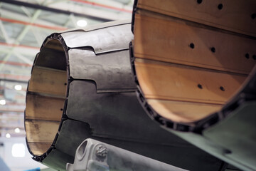Close oblique view of exhaust nozzle petal overlap and inner afterburner liner on a twin engine multirole fighter jet during maintenance