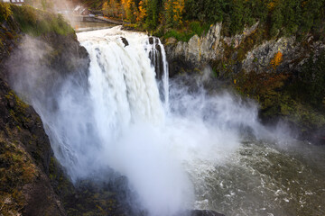 Obraz premium Snoqualmie Falls crashes over the waterfall while the Snoqualmie River is high during fall