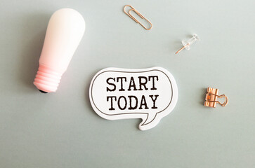 start today text on notepad and laptop on wooden background