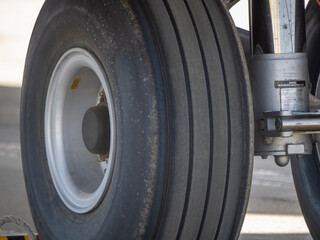 Detailed view of the twin wheel assembly and shock absorber of the aircraft nose landing gear on tarmac