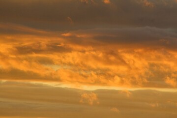 The sky is painted with fiery clouds reflecting the last rays of the sun, creating a stunning natural display.