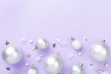 Grey Christmas balls with decor on color background, top view