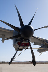 Close-up rear view of a turboprop powerplant showing eight propeller blades attached to the nacelle structure of a military cargo aircraft