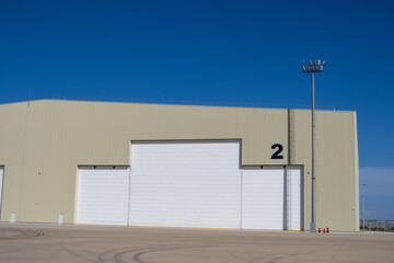 Large beige aircraft hangar with closed white maintenance doors and number marking on the exterior