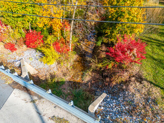 A small dried up creek and bridge during fall. 