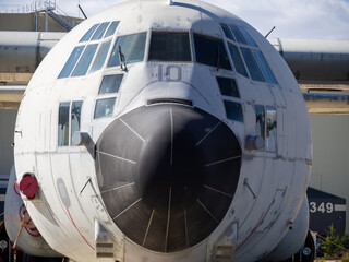 Close frontal view of weathered fuselage and cockpit glazing of preserved turboprop aircraft used as outdoor monument