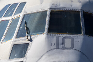 Detailed view of weathered cockpit glazing and riveted panels of old transport aircraft preserved as static monument