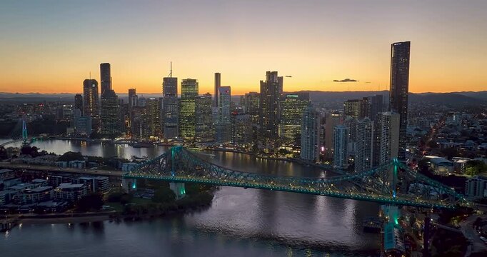 4K aerial locked down stationary day to night Time Lapse motion view of the Story Bridge and east side of Brisbane CBD and the Brisbane River, Brisbane, Queensland, Australia