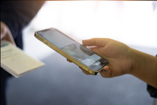 Close-up of woman scanning QR code with smartphone for digital payment or online registration