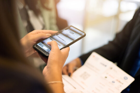 Woman using smartphone to register or check ticket at business event
