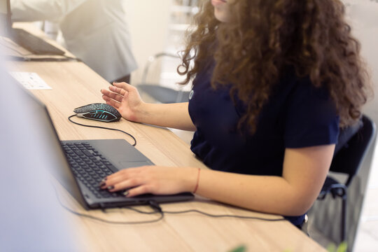Business woman registering participants on laptop at event reception desk