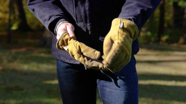 Man Putting On Work Gloves And Clapping Off Dust