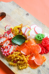 Crackers, cuanki, noodles, and complete dry seblak seasoning on a wooden tray