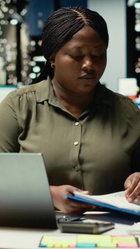 Vertical Video Engaged general manager researching market data and designing strategies to meet business goals, using spreadsheets for proofreading. Woman does after hours work for the enterprise