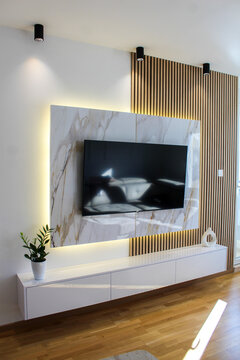 Modern living room featuring marble and wood textures, indirect LED lighting, and minimal decor for a refined look.