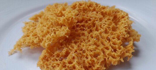 Crispy Indonesian kremesan made with tapioca and rice flour, deep fried to golden perfection. Crunchy snack served on a white plate.