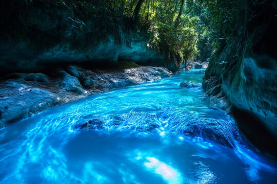 canyon river glowing under bioluminescent light, turning the waters into surreal, glowing stream