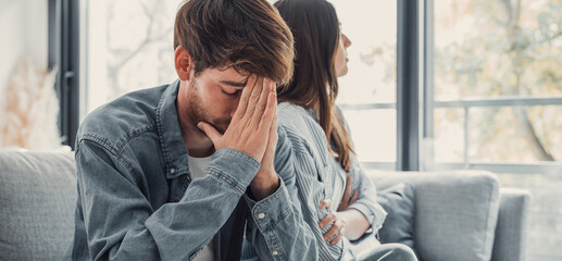 Beautiful lady is depressed, sitting on the couch talking to man, having a dispute with husband or...
