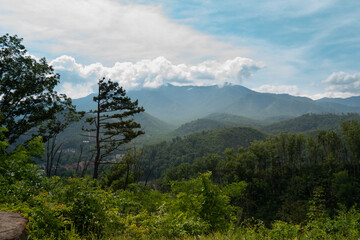 low lying clouds hovering over a blue mountain ridge on the horizon on a bright summer day in appalachia