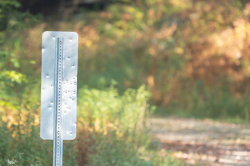 holes dents and marking from bee bees or pellets that were shot at the back of a roadsigns on a rural mountain street deep in the woods