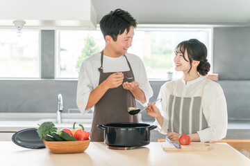 Couple, man and woman cooking and tasting food (kitchen)