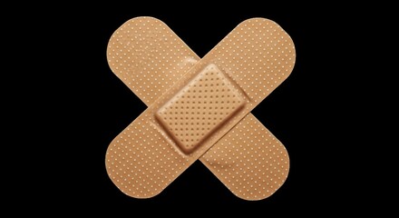 Two adhesive bandages crossed on a black background