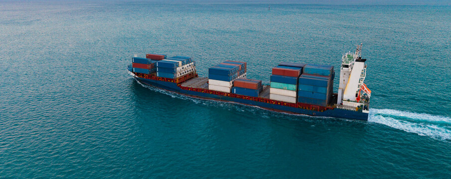 Shipping logistics. Commercial shipping. Top view. Cargo ship in sea, aerial view. Freight container loaded on cargo vessel. Aerial cargo ship with container. Cargo business. Container ship