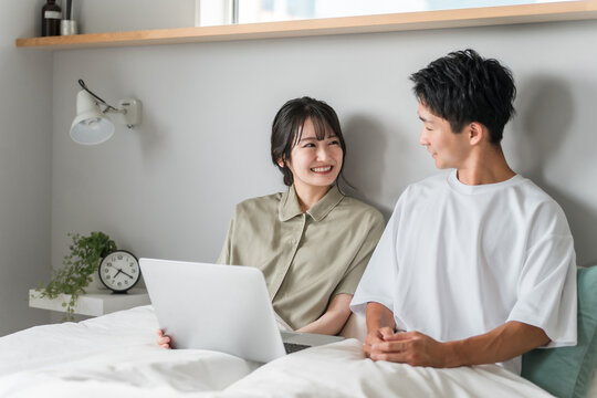 Asian couple, couple, lover, family using laptop in bedroom
