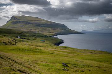 Obraz premium Low clouds hang over the remote Scandinavian island of Nolsoy in the Faroe Islands