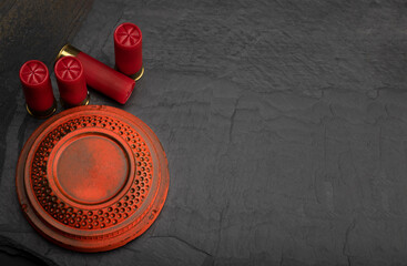 Clay shooting target with shotgun shell on black slate background , Shotgun game © Suttiwan
