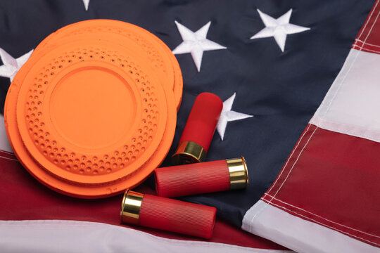 Clay shooting target with shotgun shells on usa flag background , Shotgun game