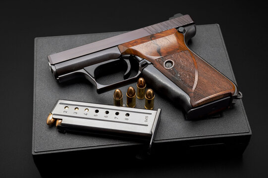 Semi automatic handgun with bullet magazine on plastic gun case background , Classic gun