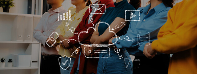 A diverse group of professionals stands together in a modern office, representing teamwork and...