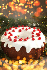 Tasty Christmas cake with red currants and fir branches on table. Bokeh lights