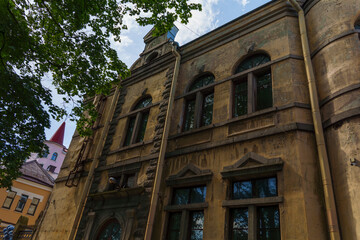 Old weathered stone building with arched windows and decorative details