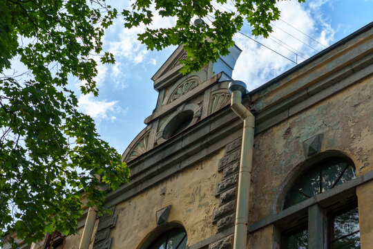 Old weathered stone building with arched windows and decorative details - Powered by Adobe