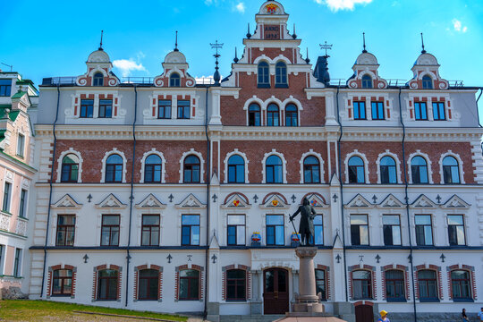Ornate historic buildings with towers and arched windows under blue sky