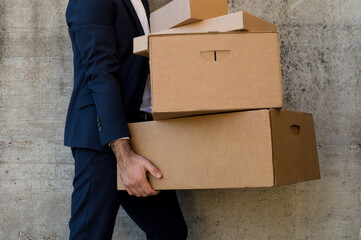 Businessman in a suit carrying unlabeled boxes