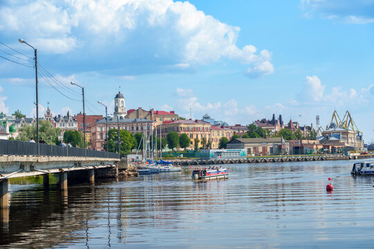 Historic waterfront cityscape with bridge and boats on a calm summer day