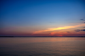 Calm sunset over smooth water with colorful sky gradient