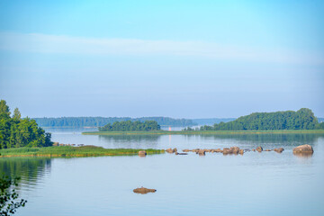 Tranquil lake with rocky shoreline and small islands at dusk