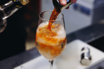 Barman mixing liquor beverages and alcohol drinks in plastic cups, bartender working, beautiful row line of different coloured cocktails on open air summer party in a bar, catering on banquet event
